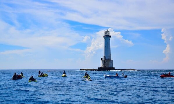 A lighthouse on a small island surrounded by water.