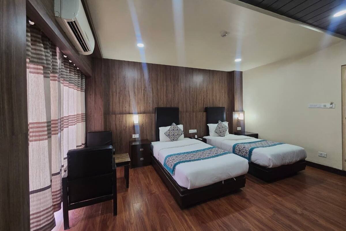 Ein Hotelzimmer mit zwei Betten, einem Schreibtisch und einem Stuhl.