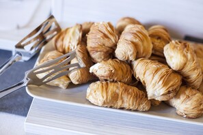 Et fad med croissanter og en gaffel på en hvid tallerken.