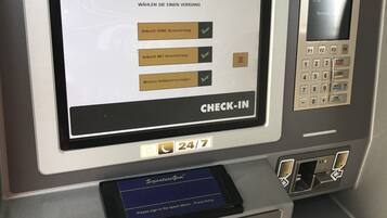 An ATM machine with a screen displaying options for account types and a check-in panel.
