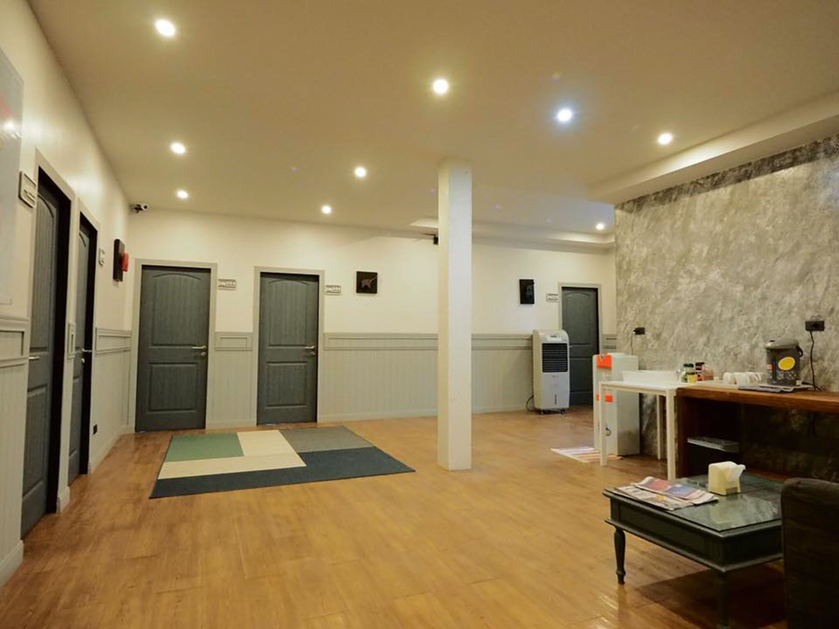 Un vestíbulo amplio con piso de madera, una recepción y una zona de estar.