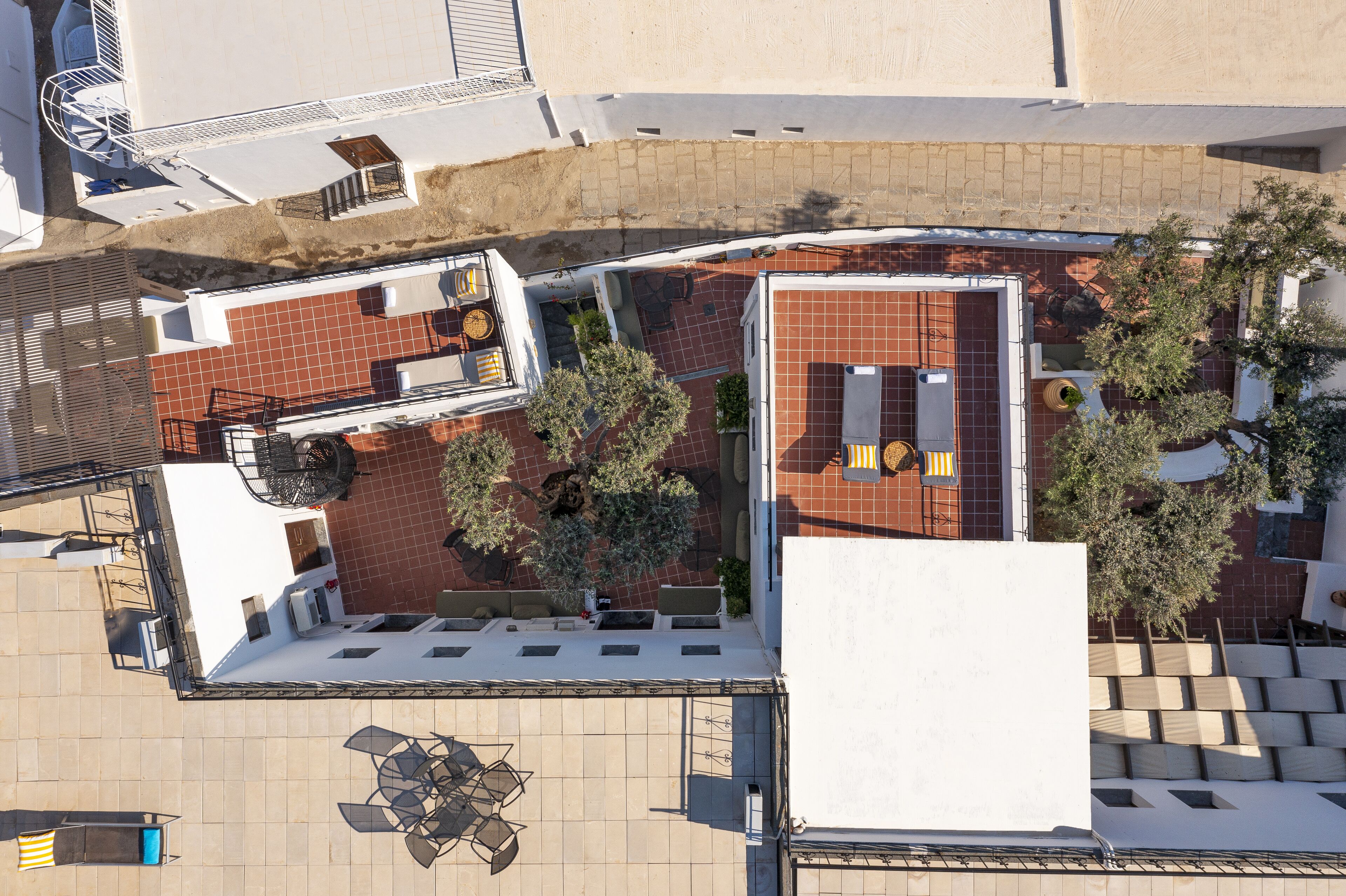 A rooftop terrace with outdoor seating, a small garden area, and a view of the surrounding buildings.