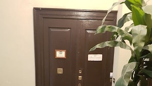 A dark wooden double door with a metal handle, a small plaque, and a welcome sign. - Bed and Breakfast Al Cucherle (Trieste)