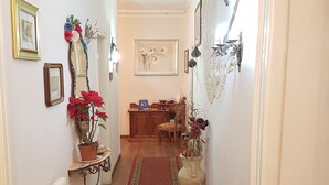 A hallway with a red patterned carpet, wooden flooring, and a radiator on the left. - Bed and Breakfast Al Cucherle (Trieste)