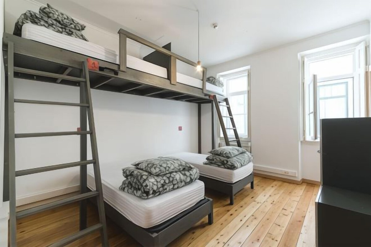 Habitación con literas, un escritorio y una ventana.