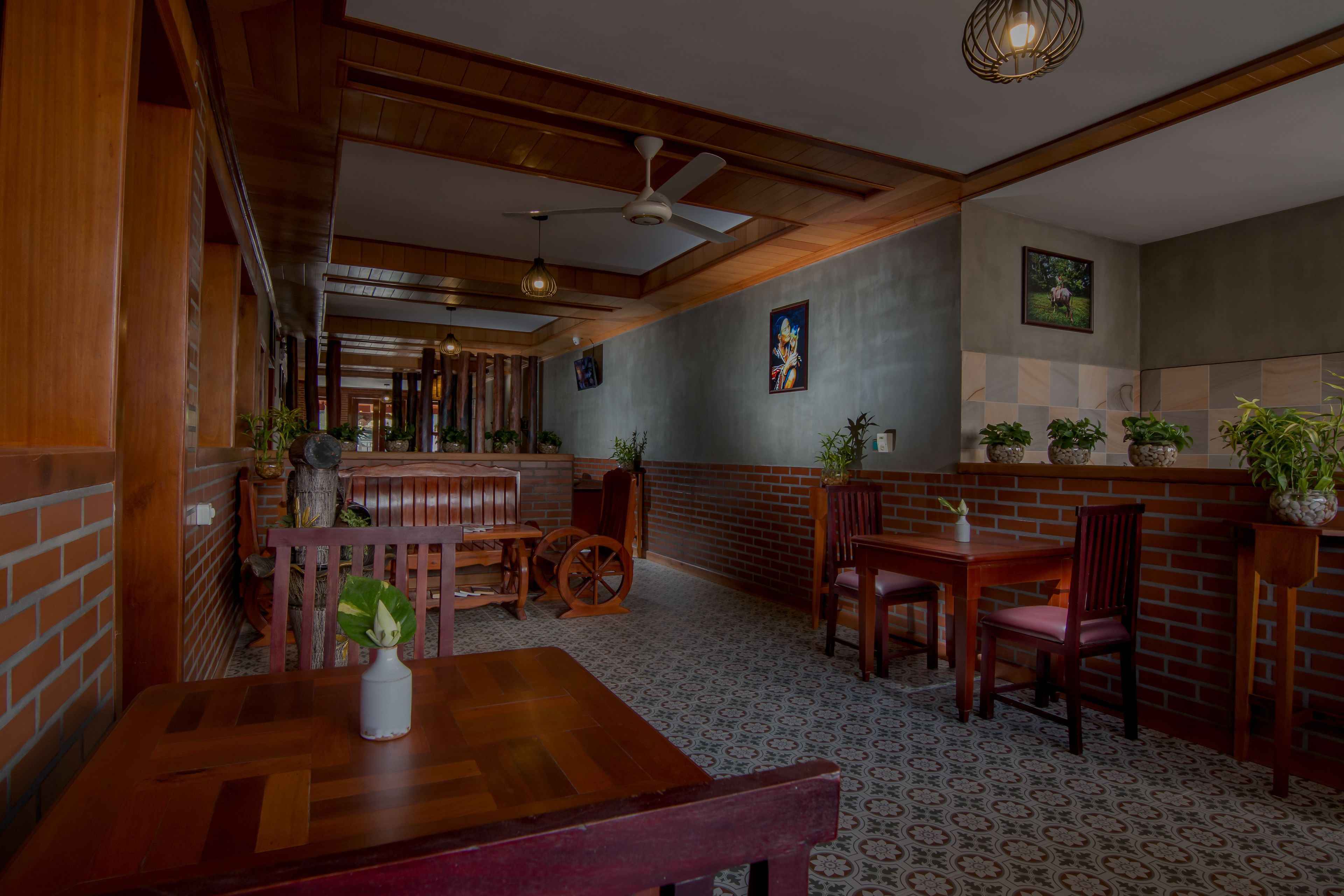 A restaurant with wooden furniture, brick walls, and a patterned floor.
