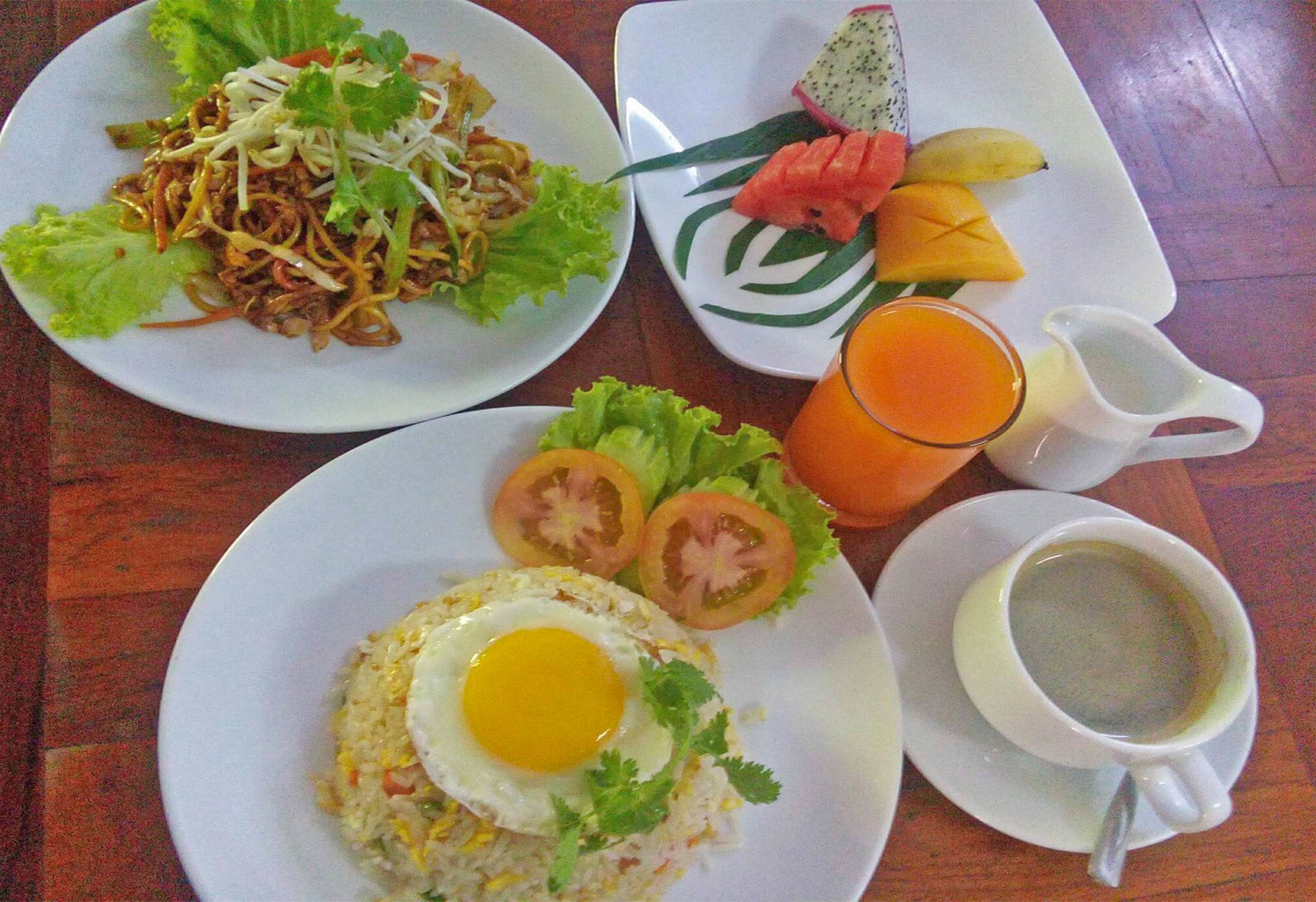 Una mesa con dos platos de comida, un vaso de jugo de naranja y una taza de café.