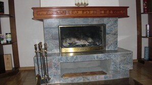 Una chimenea con un marco de mármol, un repisa de madera y un candelabro.