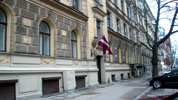 Un edificio histórico con ventanas arqueadas y una bandera.
