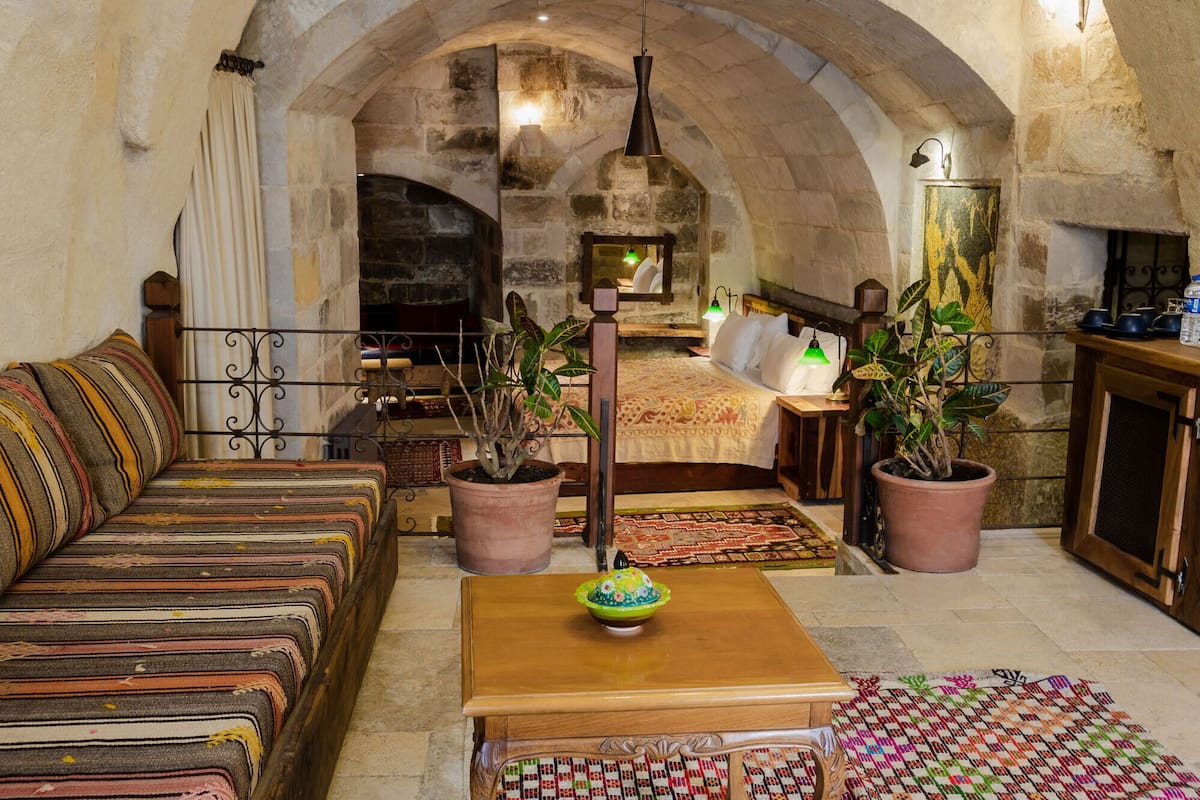 Una habitación acogedora con un sofá y una mesa de madera, además de dos plantas en macetas.