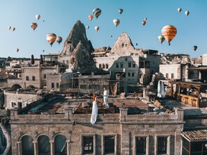 Un pueblo histórico con edificios de piedra y una formación rocosa destacada.