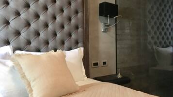 A bed with a tufted headboard, white pillows, and a quilted bedspread.