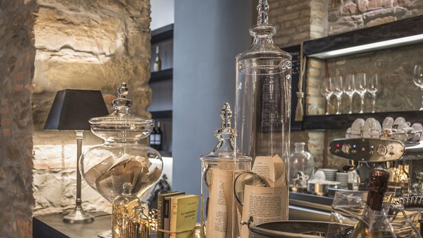A bar area with various glassware, a coffee machine, and books on the counter. - Forvm boutique Hotel (Trieste)