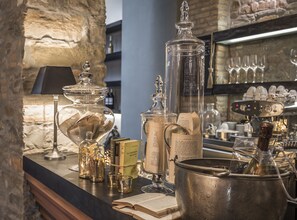Zona de bar con distintos vasos, una máquina de café y libros en la encimera.