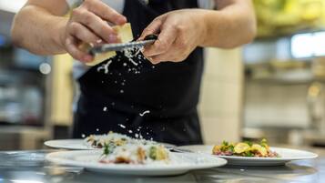 Una persona rallando queso sobre un plato.
