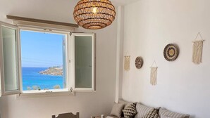 Um quarto com uma mesa de jantar, cadeiras, um sofá e um lustre.