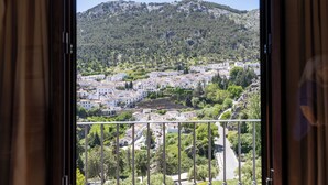 Un balcon avec vue sur la ville et sur une montagne.