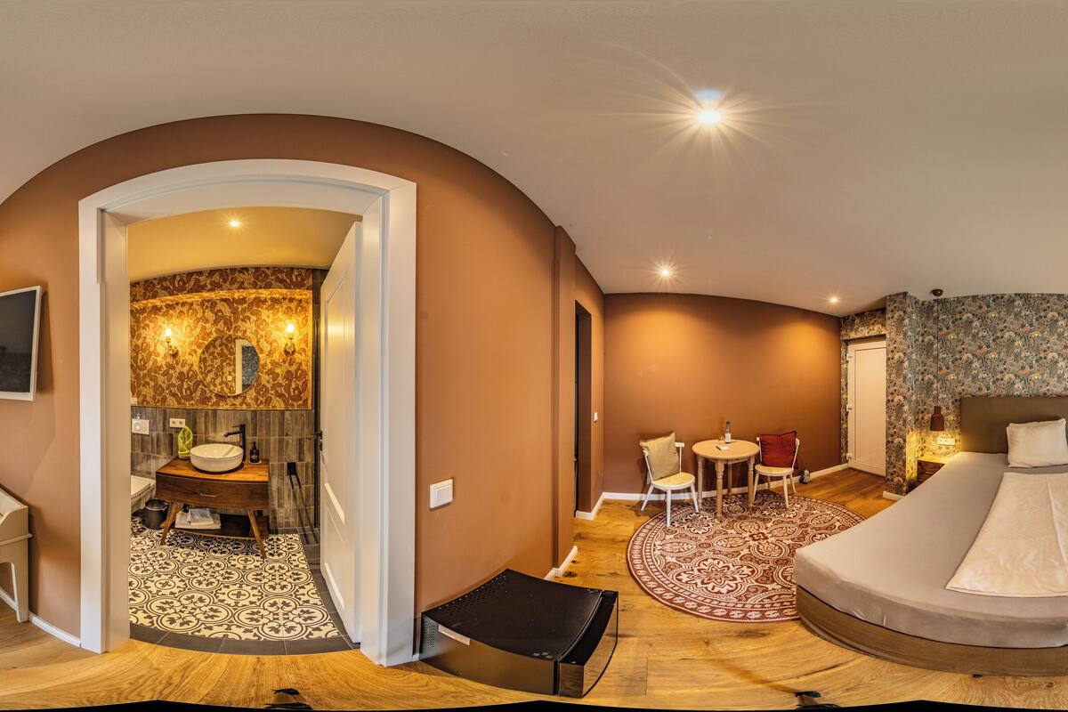 Une chambre d’hôtel moderne dotée d’un grand lit, d’un canapé, d’une télévision, d’une salle de bain et d’un coin repas.