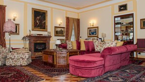 Un salon traditionnel avec une cheminée, des fauteuils confortables et un décor classique.