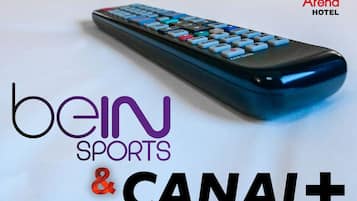 Un control remoto con la inscripción bein SPORTS & CANAL+ y Aréna HOTEL sobre un fondo blanco.