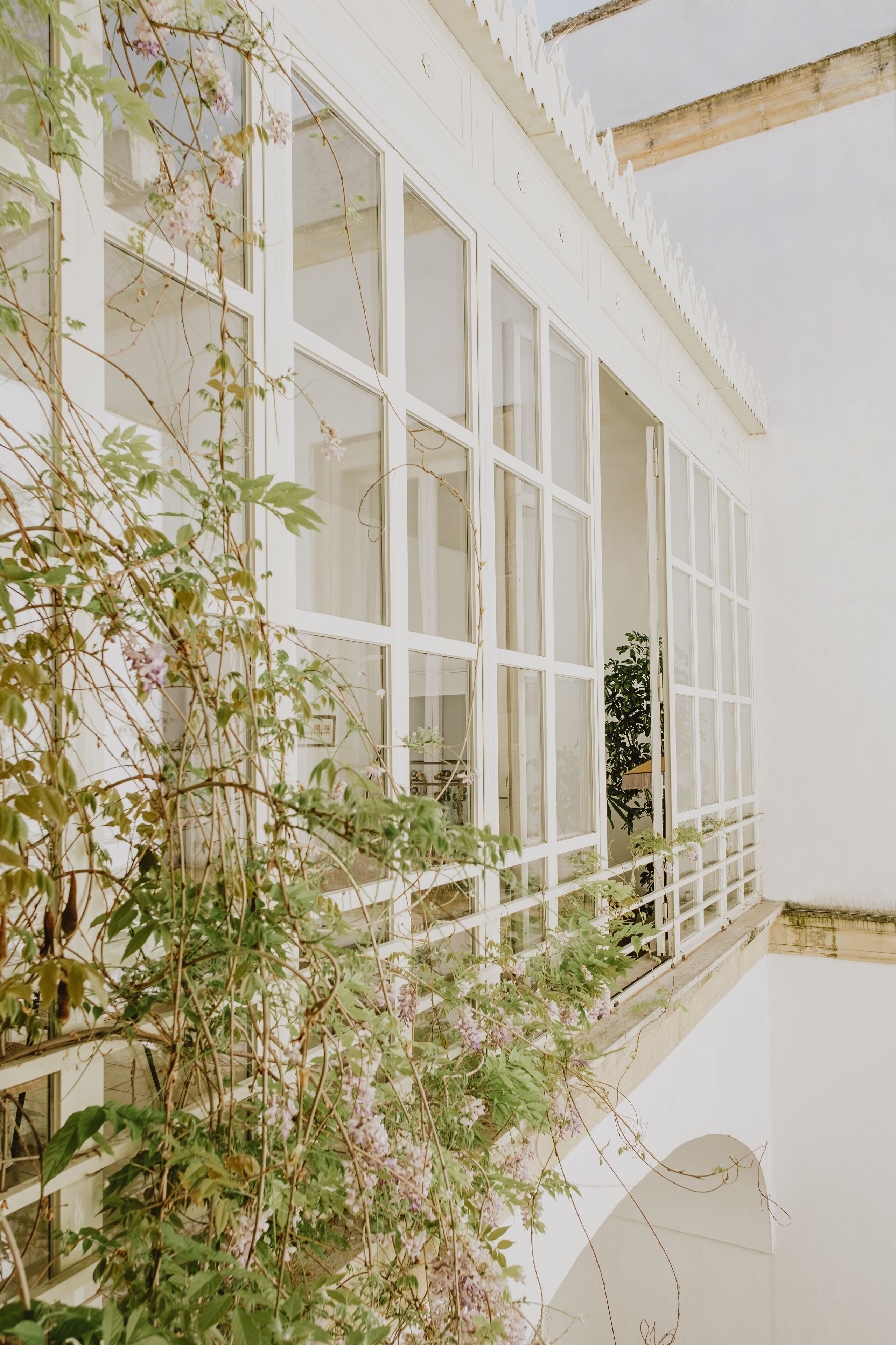 Un edificio bianco con ampie finestre e un balcone.