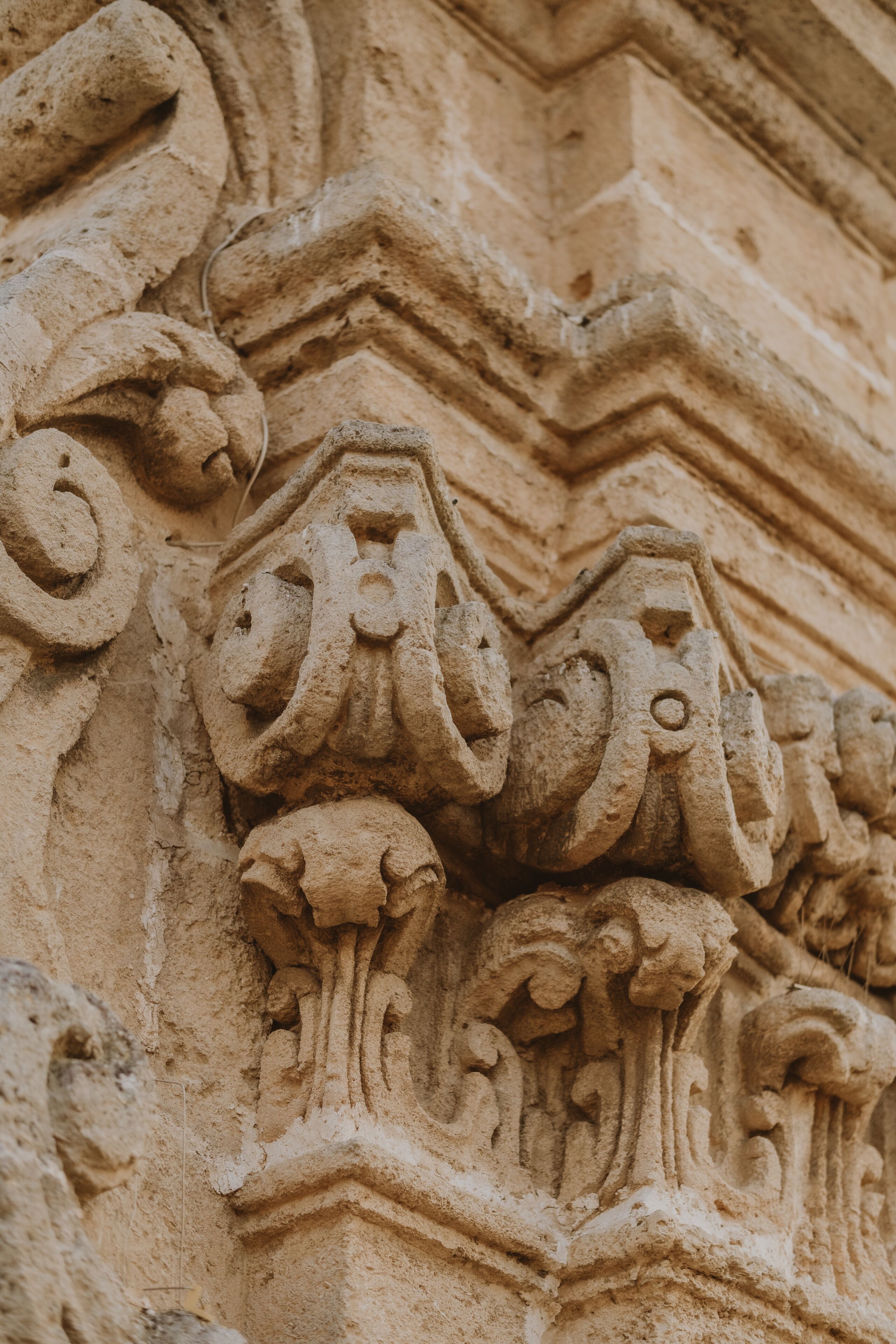 A close-up of a stone architectural carving with intricate floral and scroll designs.