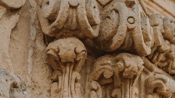 A close-up of a stone architectural carving with intricate floral and scroll designs.