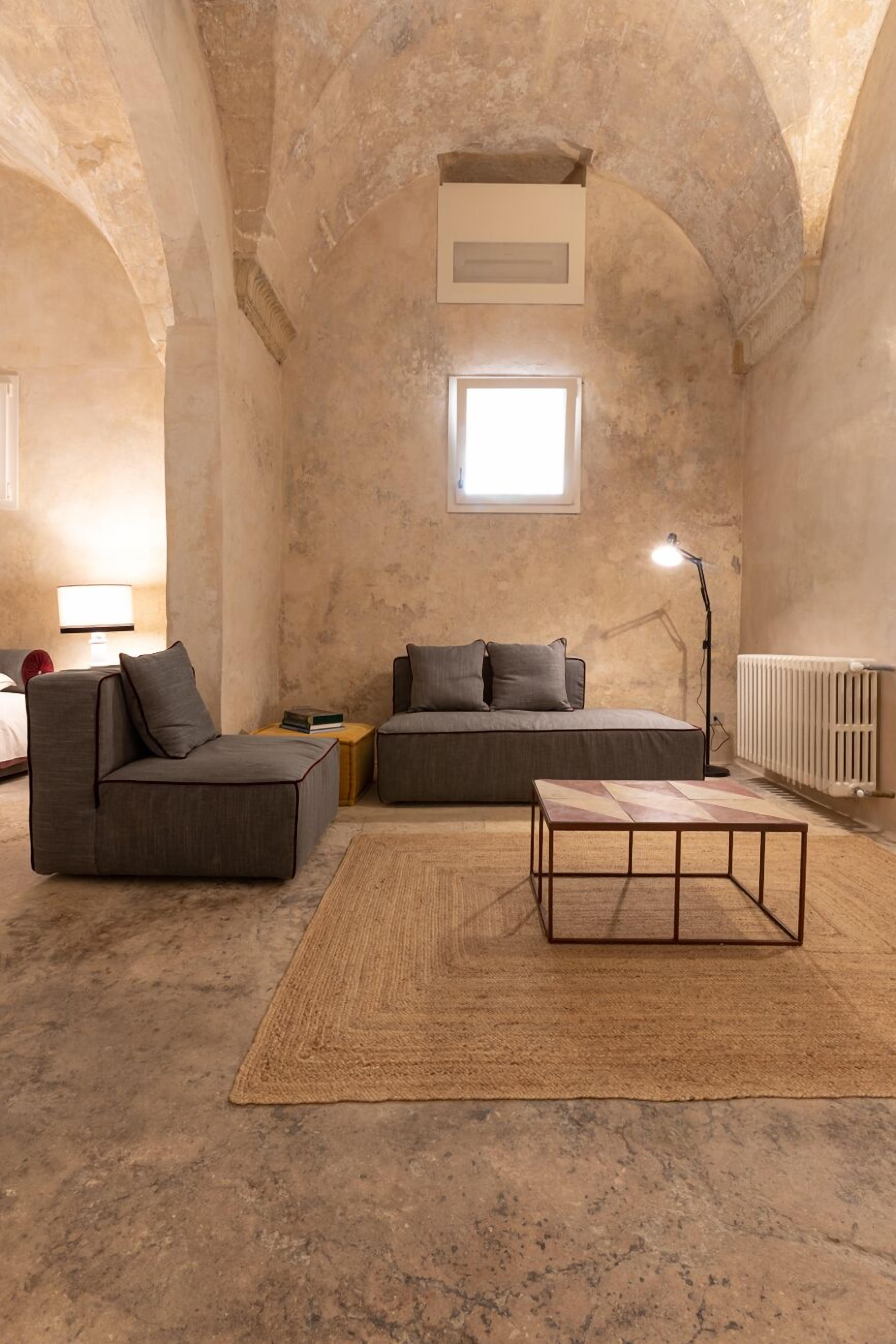 A cozy living room with a sofa, a coffee table, and a lamp.