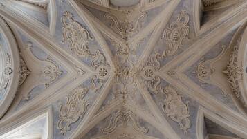 A ceiling with elaborate, symmetrical, and ornate architectural details.