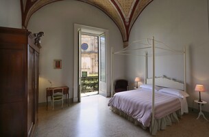 Un dormitorio con cama con dosel, un escritorio y una silla.