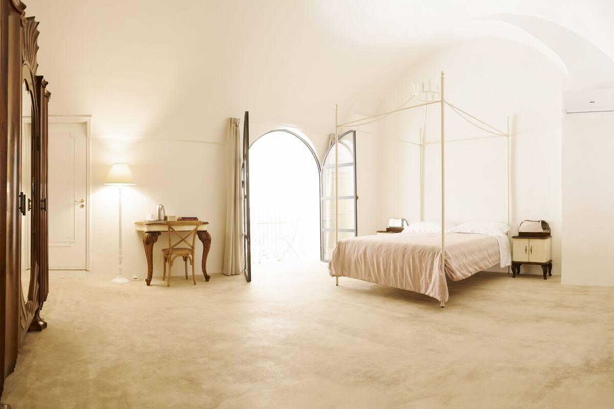 Una camera da letto con un letto a baldacchino, una scrivania con una sedia e un armadio.