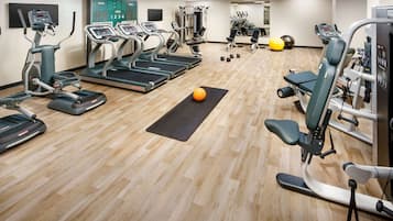 A gym with treadmills, elliptical machines, and free weights.