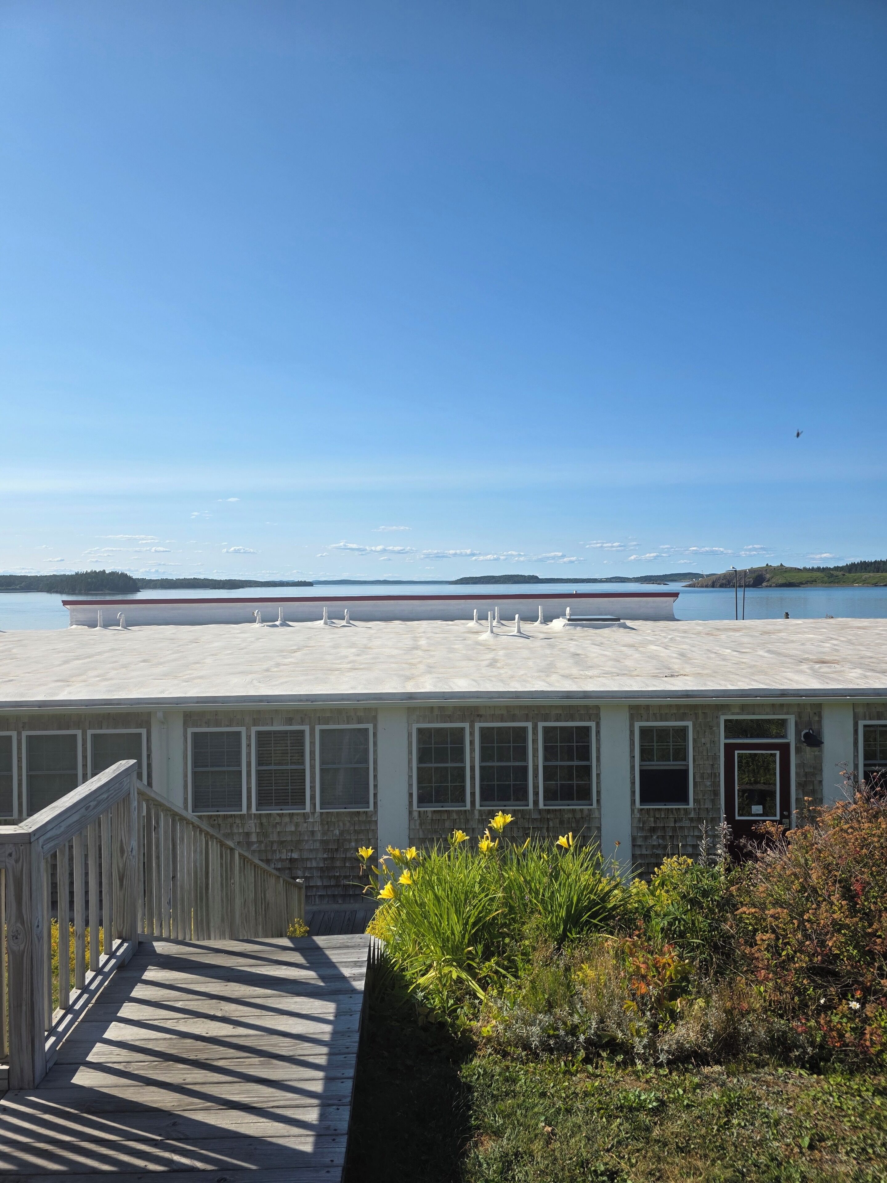 A coastal building with a deck and a view of the sea.