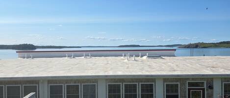 A coastal building with a deck and a view of the sea.