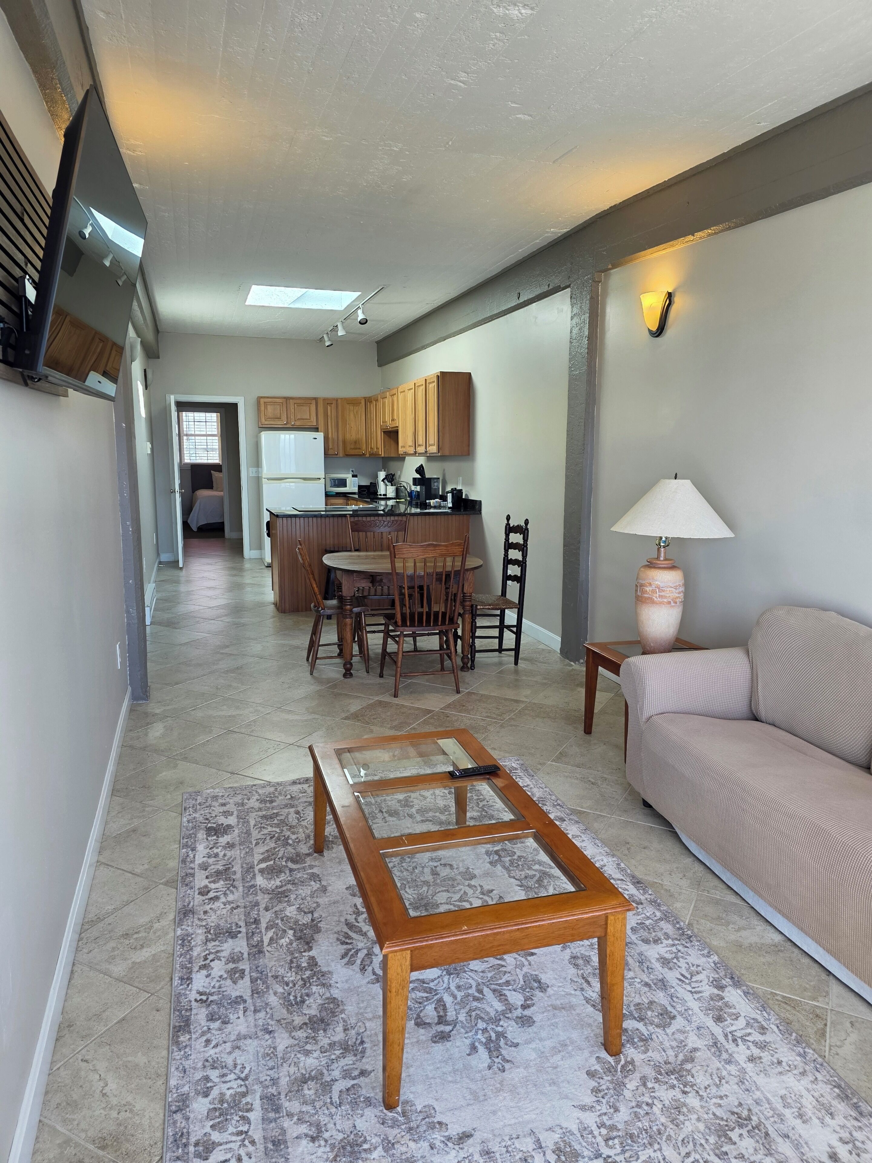 A modern living space with a kitchen, dining area, and a sofa.