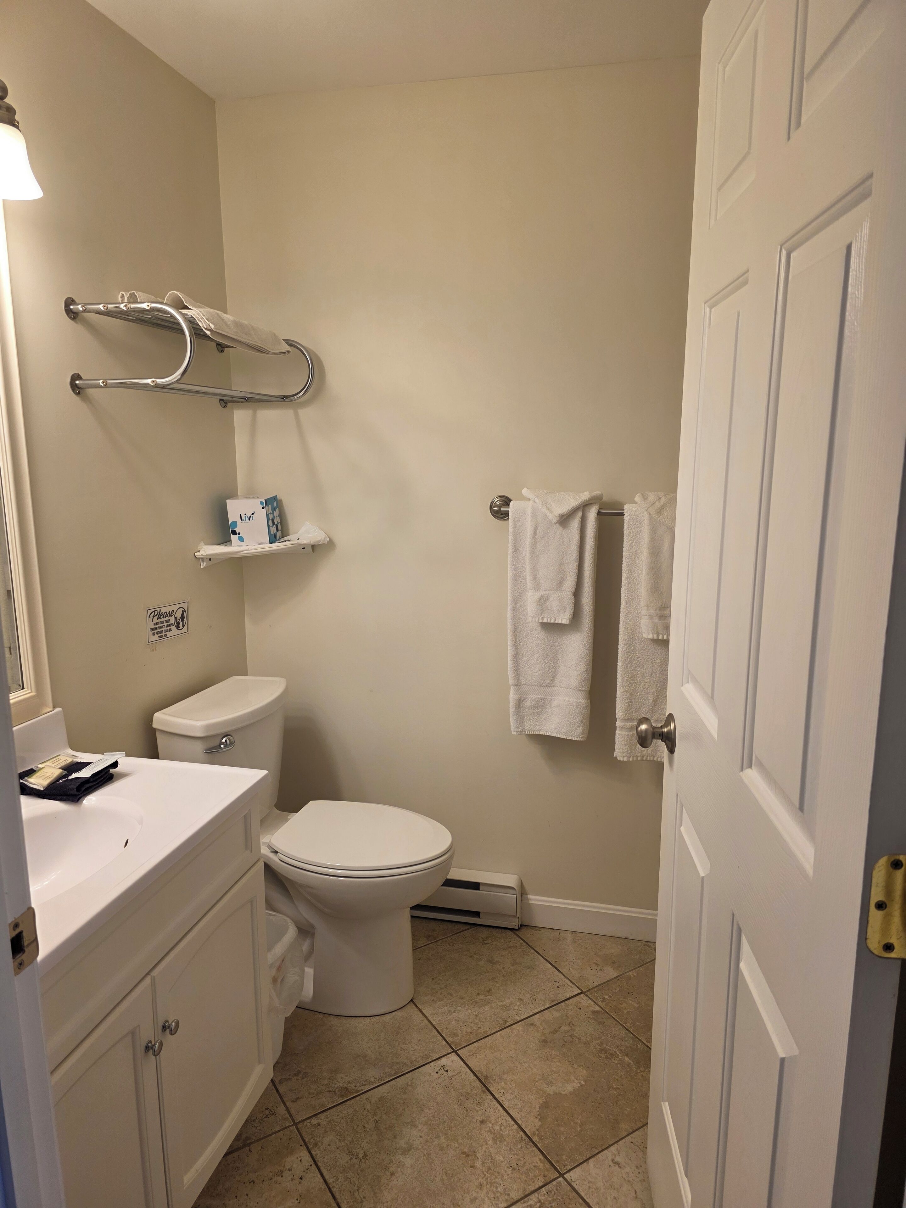 A bathroom with a toilet, sink, and towel rack.