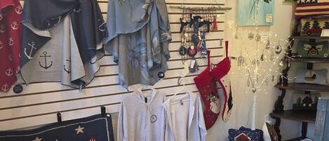 A room with a wall displaying various items including clothing, a small table with a decorative item, and a chair.