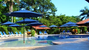 Una piscina con ombrelloni blu e lettini da relax.