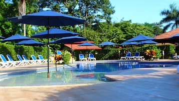 Una piscina al aire libre, sillones reclinables de piscina