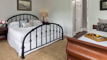 A bedroom with a bed, bedside table, lamp, and a tray with breakfast items.