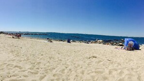 A sandy beach with a few people and a blue tent. - The Inn at Stonington (Stonington)