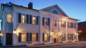 A two-story building with a central entrance, large windows, and a small balcony. - The Inn at Stonington (Stonington)