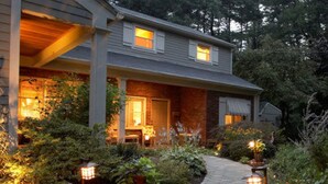 A house with a covered porch, a brick exterior, and a pathway leading to the entrance. - Journey Inn Bed & Breakfast (Hyde Park)