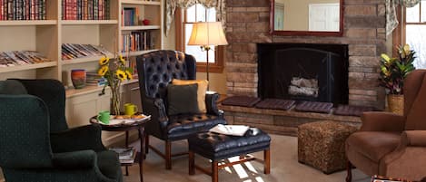 A cozy living room with a fireplace, bookshelves, and comfortable seating.
