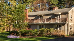 A two-story house with a balcony, surrounded by a well-maintained garden and trees. - Journey Inn Bed & Breakfast (Hyde Park)
