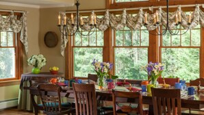 A dining area with a wooden table set for four, surrounded by chairs. - Journey Inn Bed & Breakfast (Hyde Park)