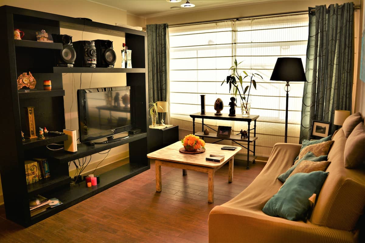 A living room with a television, wooden coffee table, and a sofa.