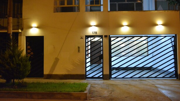 Un bâtiment doté de deux grandes portes de garage, avec le numéro « 178 » au-dessus de la porte de droite, et un petit arbre au premier plan.