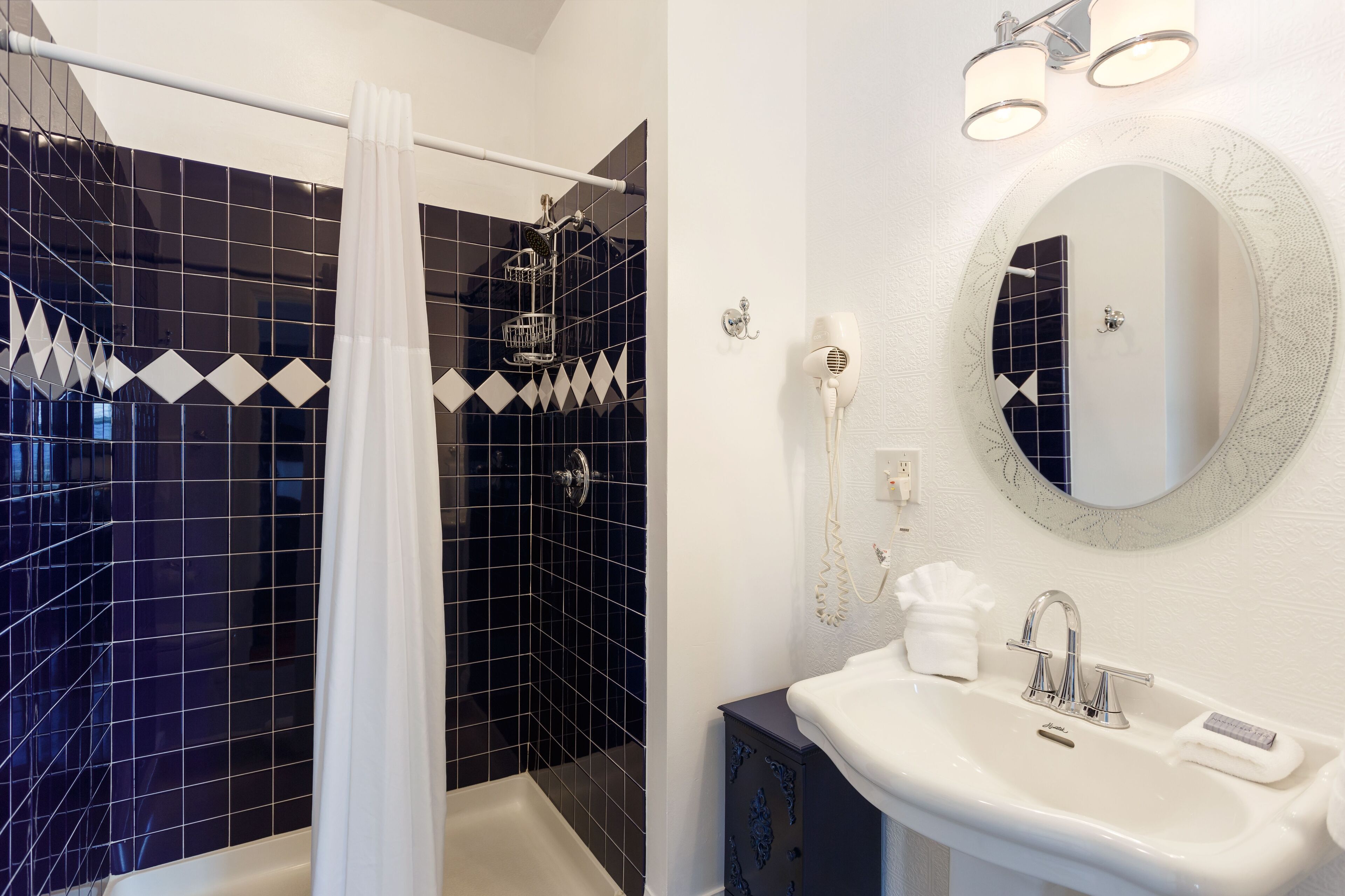 A modern bathroom with a shower, a sink, and a mirror.