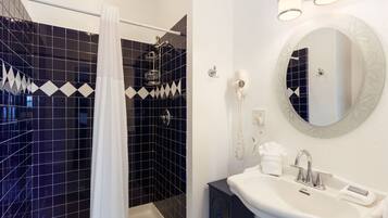 A modern bathroom with a shower, a sink, and a mirror.